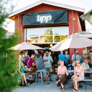 Crowd enjoying craft beer on the outdoor patio at UPP Liquids, a brewer-owned brewery and restaurant in Bend, Oregon