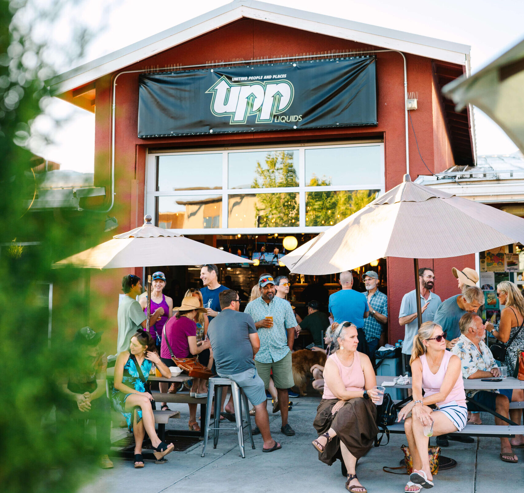 Crowd enjoying craft beer on the outdoor patio at UPP Liquids, a brewer-owned brewery and restaurant in Bend, Oregon